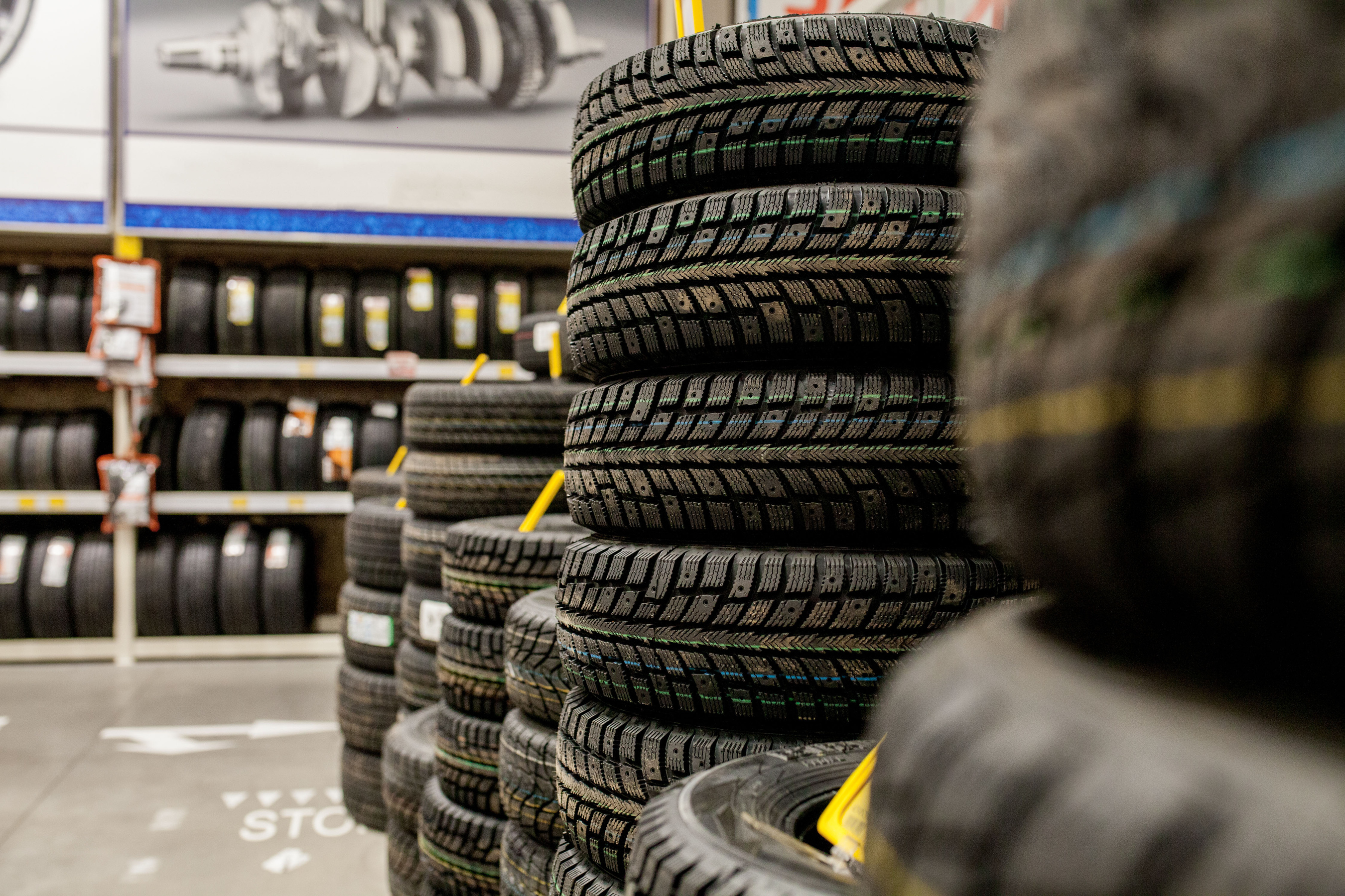 Car tires and wheels at warehouse in tire store.